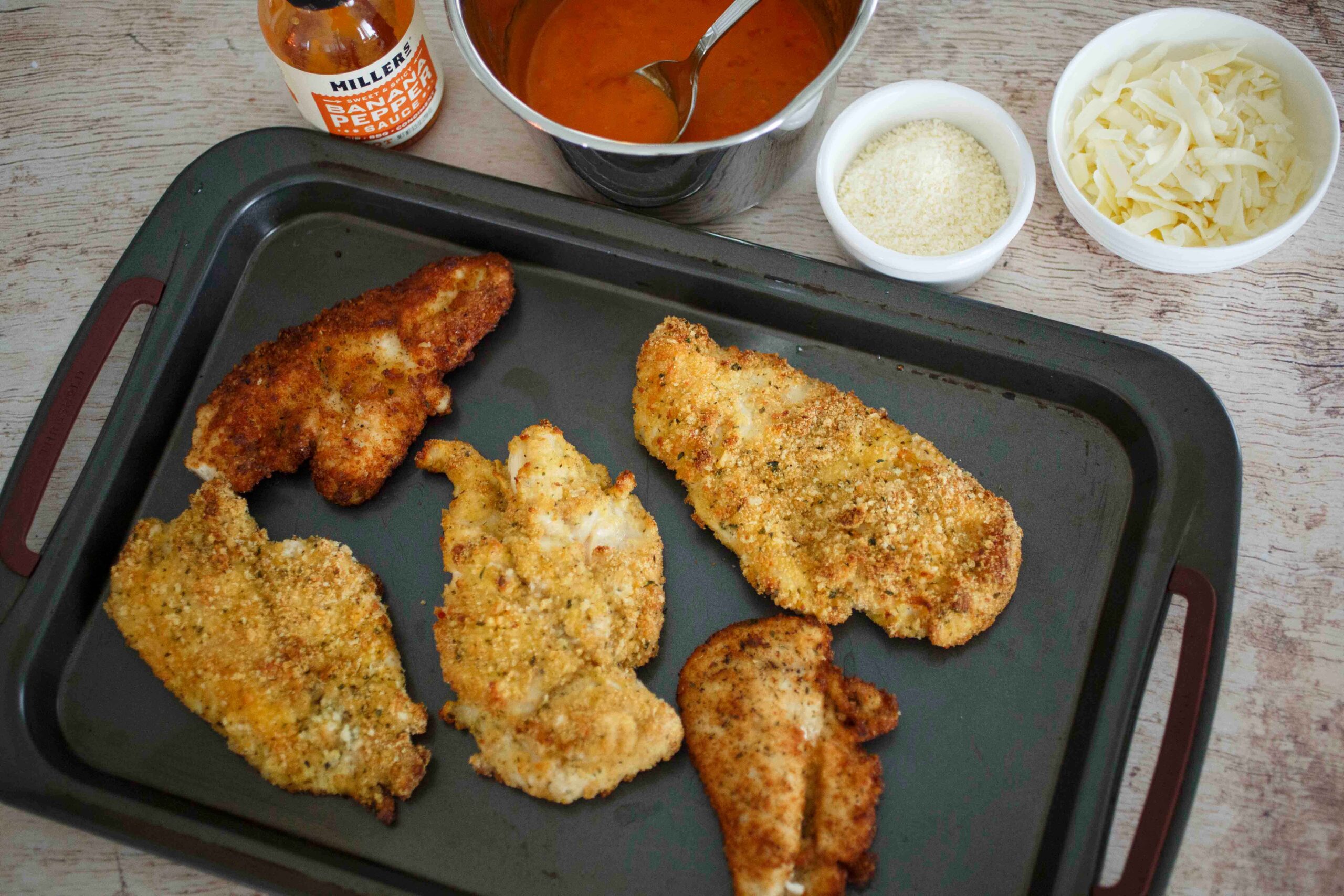 top the baked chicken with hot sauce and cheese