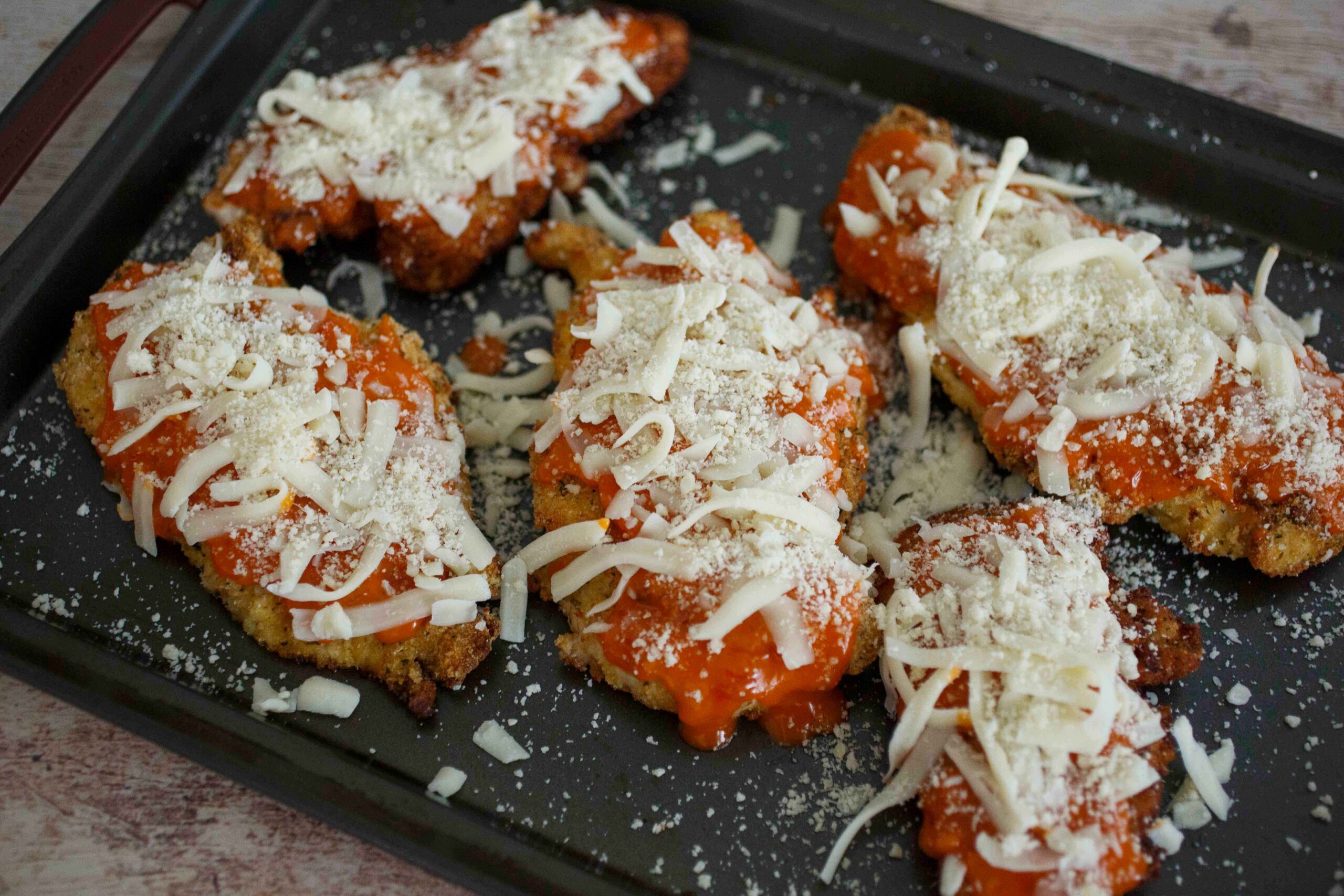 top the baked chicken with hot sauce and cheese